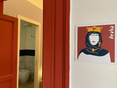 a painting of a woman with a crown on a wall at Le Dame di Sicilia Sicilian Vintage Rooms in Palermo