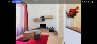 a living room with a vase of red roses in a living room at Palermo sweet house in Palermo