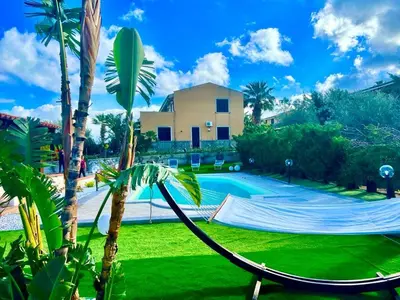 a hammock in a yard next to a swimming pool at Doppia villa indipendente/clara in Mandra Capreria