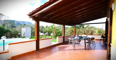 a patio with a table and chairs and a pool at Doppia villa indipendente/clara in Mandra Capreria