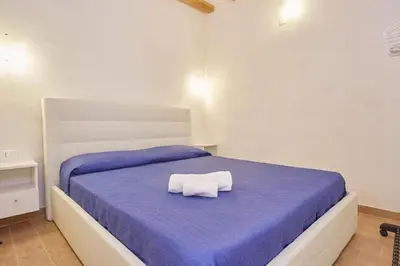 a bedroom with a blue bed with a towel on it at CASA FATIMA in Castellammare del Golfo