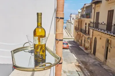 a bottle of wine sitting on top of a balcony at CASA FATIMA in Castellammare del Golfo