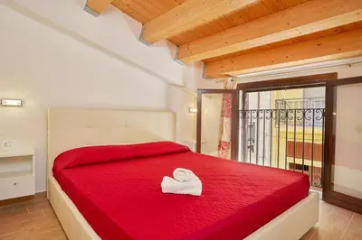a bedroom with a red bed with a towel on it at CASA FATIMA in Castellammare del Golfo