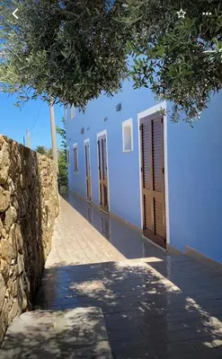 a row of doors on a blue building at B&B Pelagos in Castellammare del Golfo