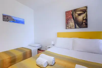 a bedroom with two beds and a painting on the wall at Casa Querencia rooms in Palermo