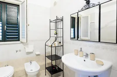 a bathroom with a sink and a toilet and a mirror at Casa Querencia rooms in Palermo