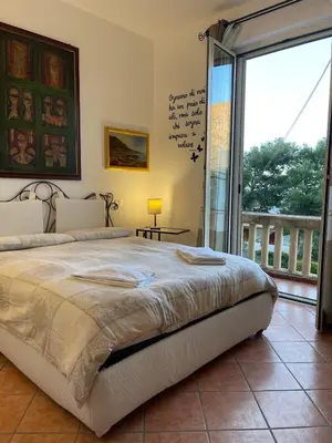 a bedroom with a large bed and a balcony at FINESTRA SUL MARE in Palermo