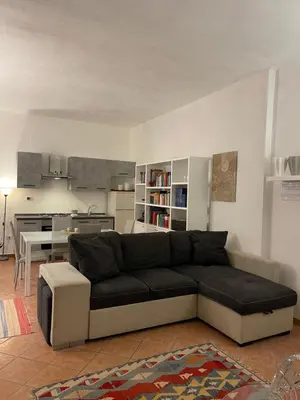 a living room with a couch and a kitchen at FINESTRA SUL MARE in Palermo