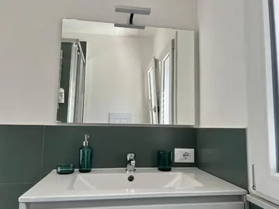 a bathroom with a white sink and a mirror at M'AMA apartment in Ficarazzi