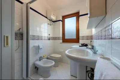a white bathroom with a sink and a toilet at Marconi in San Vito lo Capo