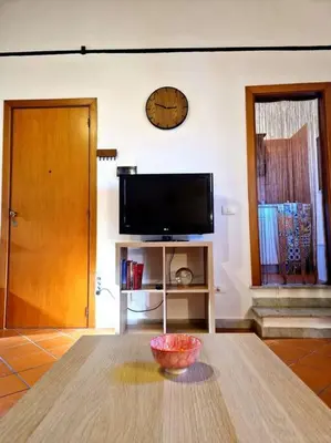a living room with a table and a television at Wood House - Palermo in Palermo