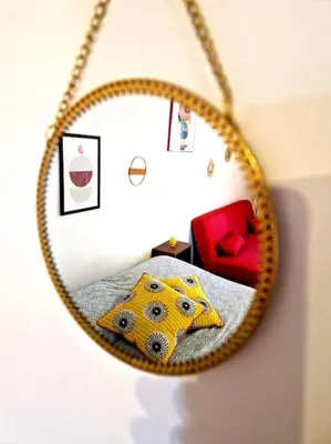 a mirror reflecting a bedroom with a bed and a red chair at Wood House - Palermo in Palermo