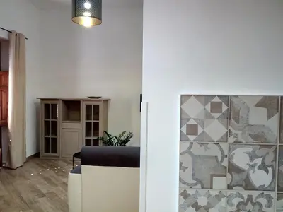 a living room with a table and a wall at Ancilinas House in Castellammare del Golfo