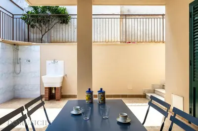 a table with two chairs and a sink in a room at La Dimora del Mare by Domus Sicily in Mondello