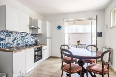 a kitchen and dining room with a table and chairs at La Dimora del Mare by Domus Sicily in Mondello