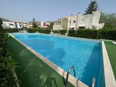a large blue swimming pool in front of a building at Flat with Terrace & Pool in Mondello