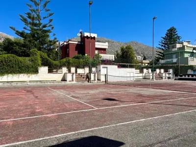 a tennis court in front of a building at Flat with Terrace & Pool in Mondello