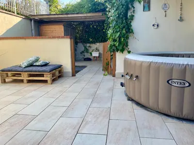 a patio with a tub and a bed on a patio at Flat with Terrace & Pool in Mondello