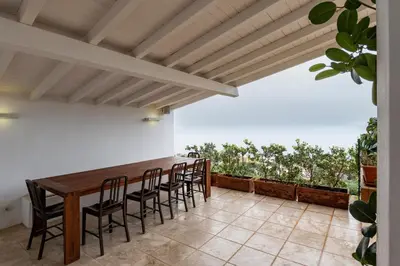 a room with a table and chairs and a kitchen at Addaura Home in Palermo