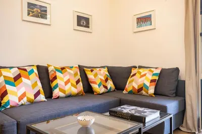 a living room with a blue couch with colorful pillows at Bibi house a San Giovanni degli Eremiti in Palermo