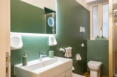 a bathroom with a white sink and a green wall at Bibi house a San Giovanni degli Eremiti in Palermo