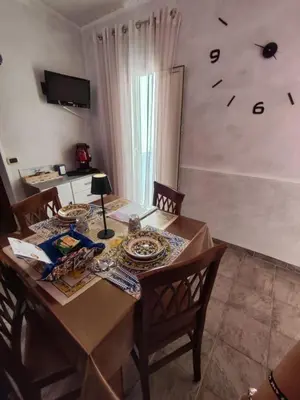 a dining room table with a clock on the wall at Casa Swamy in Palermo