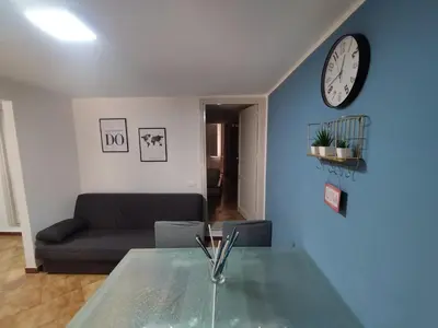 a living room with a couch and a clock on a wall at Montesanto Home in Palermo