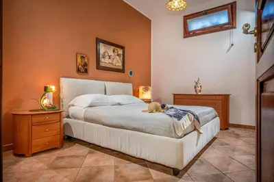 a bedroom with a bed and a table and a window at Villa Miceli in Scopello