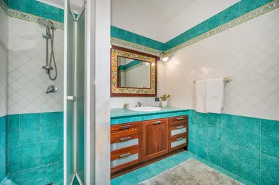 a blue bathroom with a sink and a mirror at Villa Miceli in Scopello