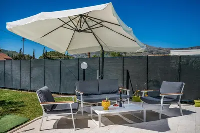 a patio with two chairs and an umbrella at Villa Miceli in Scopello