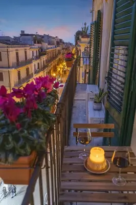 a balcony with tables and chairs and flowers on a building at 70 Lab Apartment in Palermo