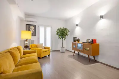 a living room with a yellow couch and a chair at 70 Lab Apartment in Palermo
