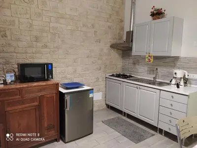 a kitchen with white cabinets and a sink and a refrigerator at bb45 superior holiday's house CIR 19082053C204471 in Palermo
