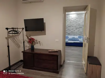 a living room with a tv and a door to a bedroom at bb45 superior holiday's house CIR 19082053C204471 in Palermo
