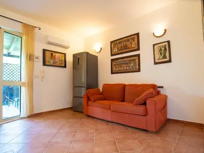 a living room with an orange couch and a refrigerator at VILLA ANGELA TRABIA in Trabia