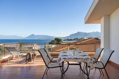 a table and chairs on a balcony with a view of the ocean at Kastemar in Porticello