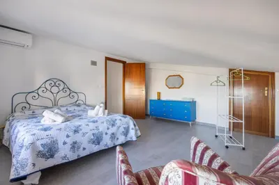 a bedroom with a bed and a blue dresser and chairs at Kastemar in Porticello