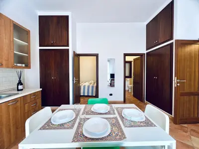 a kitchen with a white table with white plates on it at Casa Carlotta Apartments in Terrasini