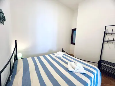 a bedroom with a striped bed with towels on it at Casa Carlotta Apartments in Terrasini