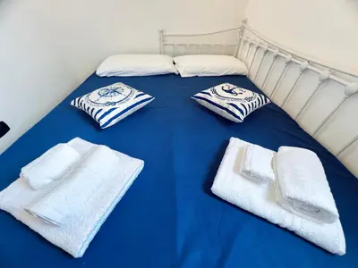 a blue bed with white towels on top of it at Casa Carlotta Apartments in Terrasini