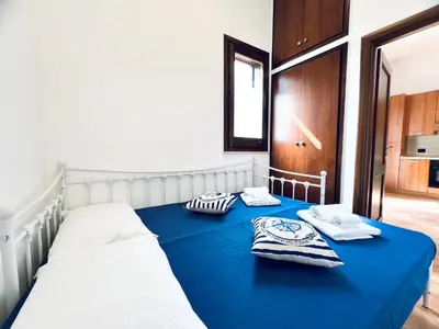 a bedroom with a blue bed with towels on it at Casa Carlotta Apartments in Terrasini