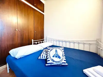 a bedroom with a blue bed with two pillows on it at Casa Carlotta Apartments in Terrasini