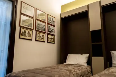 a bedroom with a bed and framed pictures on the wall at Le Case Di Romeo Alla Vucciria in Palermo