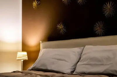 a bedroom with a bed with white pillows and a black wall at Le Case Di Romeo Alla Vucciria in Palermo