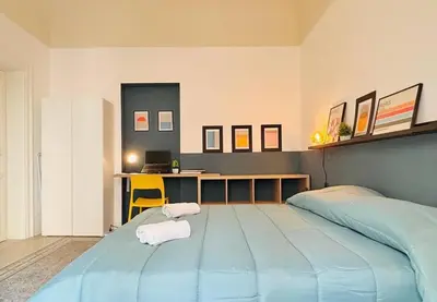 a bedroom with a large blue bed and a desk at Corte del Tribunale in Palermo