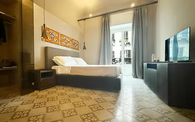 a bedroom with a bed and a television in it at Palazzo Liberty Unique Hotel by Geocharme in Palermo