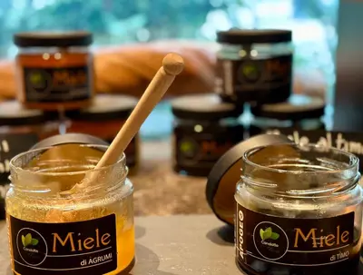 a jar of honey with a wooden spoon in it at Palazzo Liberty Unique Hotel by Geocharme in Palermo
