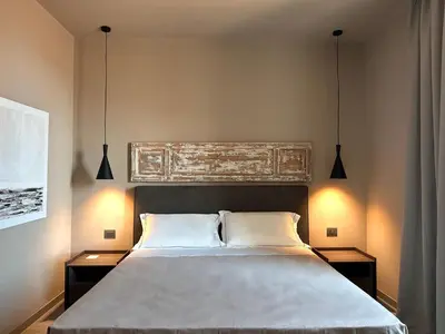 a bedroom with a large bed with two night stands at Palazzo Liberty Unique Hotel by Geocharme in Palermo