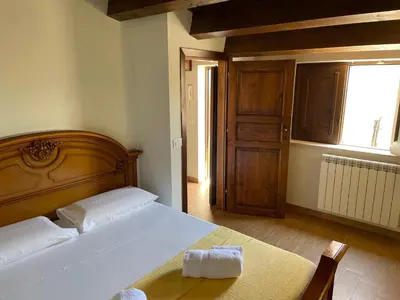 a bedroom with a bed with a wooden headboard and a window at Appartamento in Centro Storico a Termini Imerese - Eden Holiday Home in Termini Imerese
