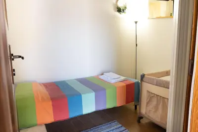 a bedroom with a rainbow bed and a lamp at Appartamento in Centro Storico a Termini Imerese - Eden Holiday Home in Termini Imerese